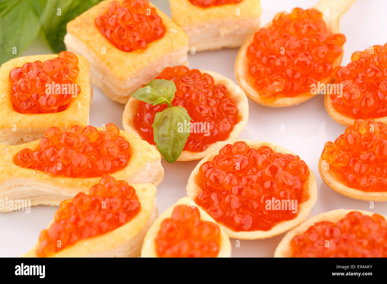 Roter Kaviar in Gebäck und Salat auf Teller. Stockfoto