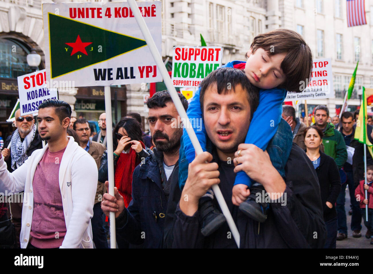 London, UK. 19. Oktober 2014. Hunderte von Londons kurdische Gemeinschaft März Throgh der Hauptstadt aus Protest gegen ISIS und der türkischen Regierung, die sie beschuldigen, indem nicht immer beteiligt an militärischen Aktionen gegen den is, der mit den Dschihadisten um zu tilgen, Kurden, die lange für ein unabhängiges Kurdistan gekämpft haben. Bild: Ein Kind schläft, wie sein Vater marschiert. Bildnachweis: Paul Davey/Alamy Live-Nachrichten Stockfoto