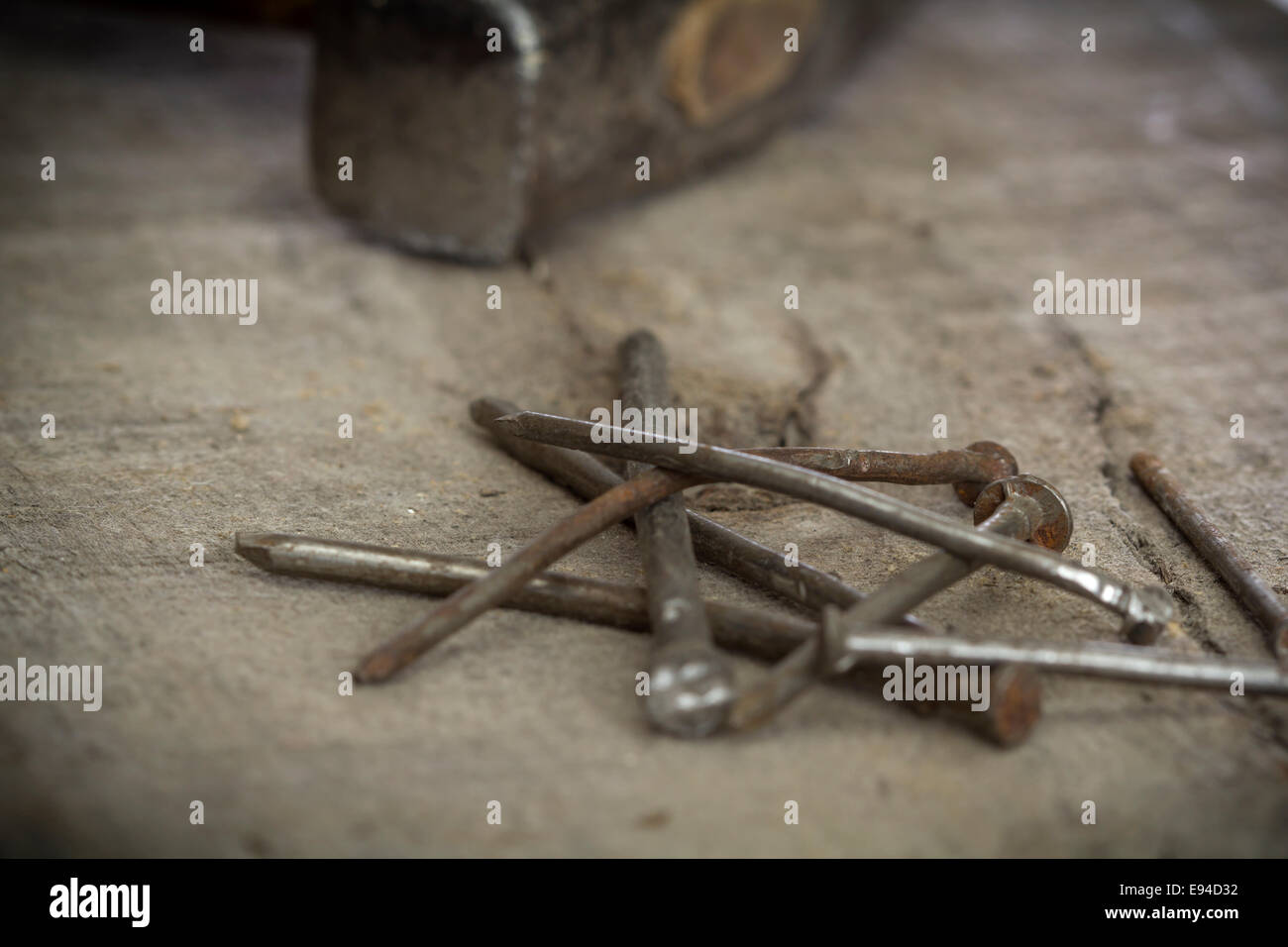 alte rostige Nägel und einen Hammer auf hölzernen Hintergrund Stockfoto