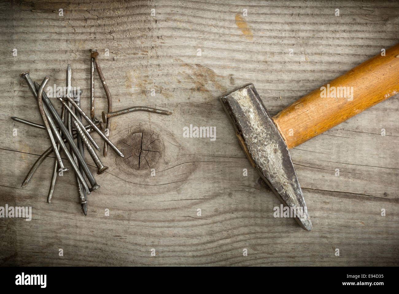 Alte rostige Nägel und Hammer auf hölzernen Hintergrund Stockfoto