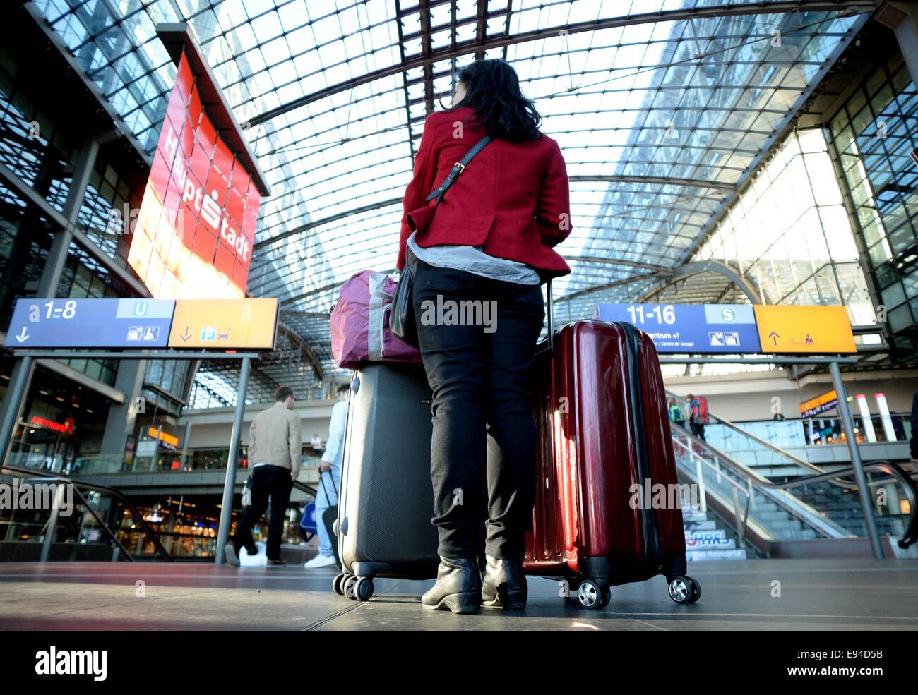 Berlin, Deutschland. 19. Oktober 2014. Ein Wmoan wartet mit ihren Koffern für ankommende Züge am Hauptbahnhof in Berlin, Deutschland, 19. Oktober 2014. Auch am zweiten Tag des Streiks sind viele lokale und nationale Züge außer Betrieb. Foto: Britta Pedersen/Dpa/Alamy Live News Stockfoto