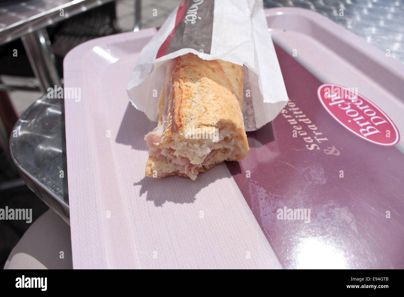 Eine Hälfte gegessen Schinken und Käse Baguette-Sandwich von Brioche Dorée, ein französischer Sandwich Shop und Bäckerei-Kette Stockfoto