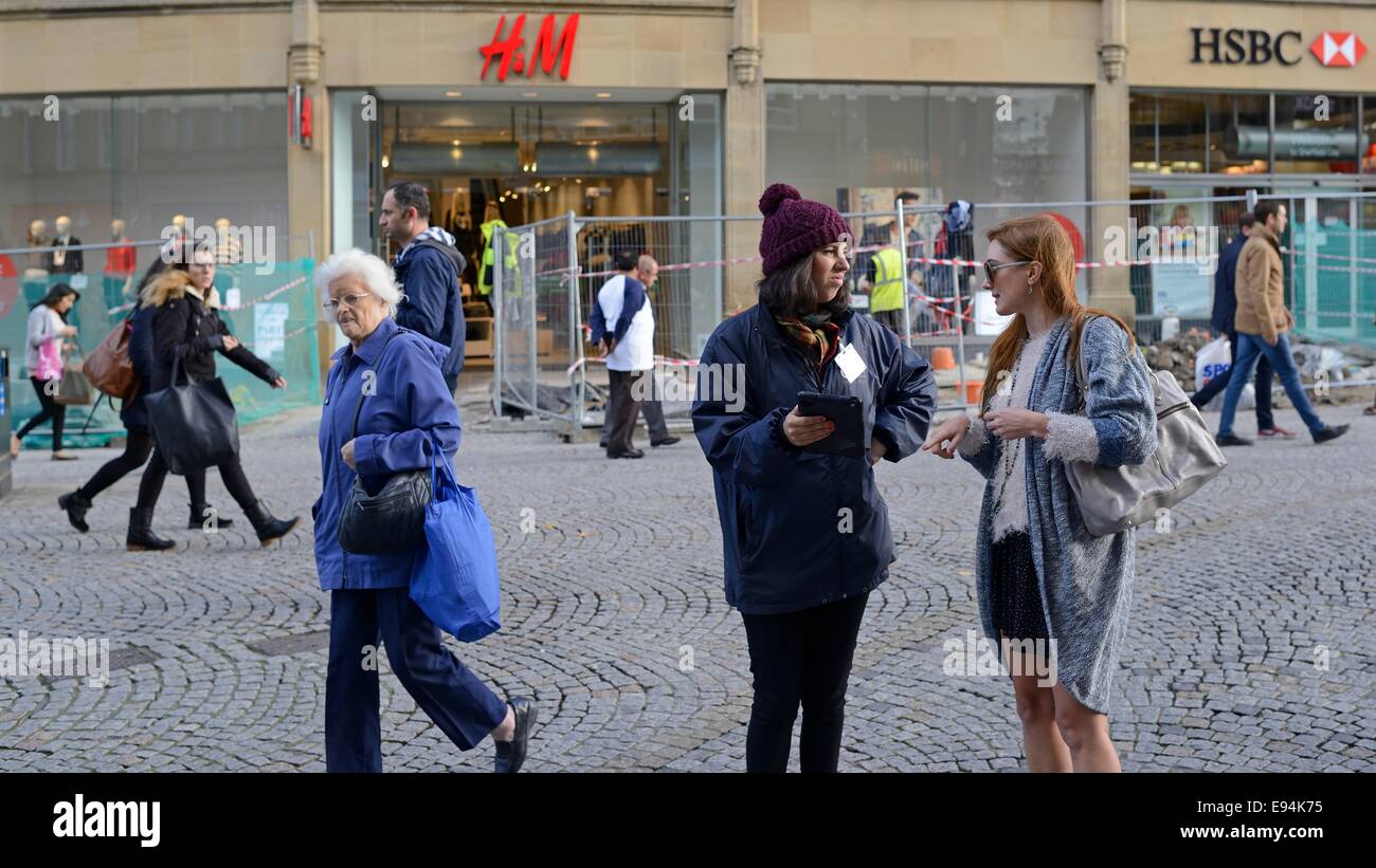 Frau im Gespräch mit Käufern in Straße Umfrage in der Fußgängerzone Stockfoto