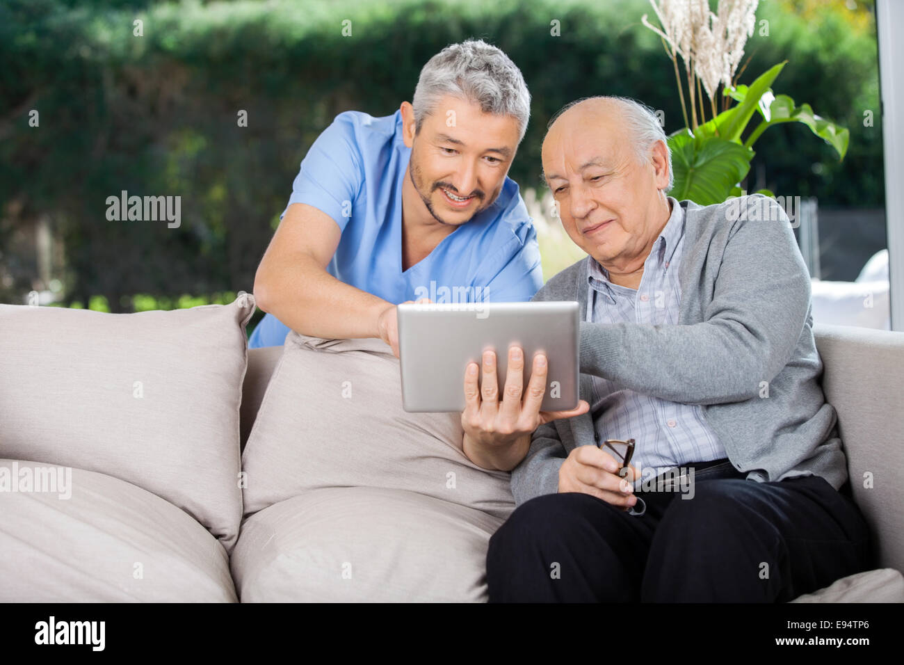 Männliche Hausmeister und Senior woman mit Tablet PC Stockfoto