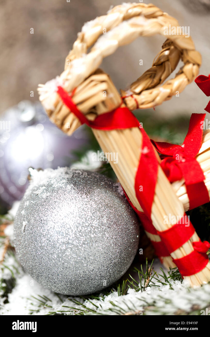 Silber Glitzer texturiert Weihnachtskugel auf dem Ast einer Kiefer oder Tanne Baum, bestreut mit Schnee und Zapfen mit handgefertigten stra Stockfoto