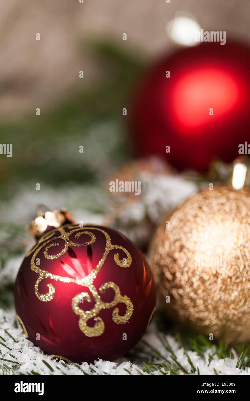 Silber Glitzer texturiert Weihnachtskugel auf dem Ast einer Kiefer oder Tanne Baum, bestreut mit Schnee und Zapfen mit handgefertigten stra Stockfoto