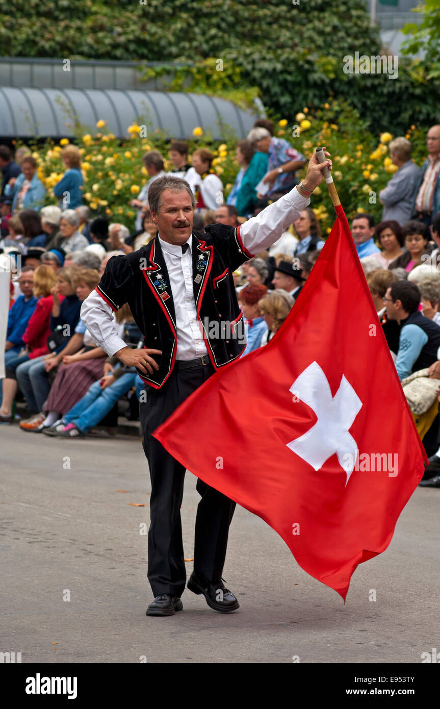 Flag-Waver mit einer Schweizer Flagge an einem Trachtenumzug, Interlaken, Kanton Bern, Schweiz Stockfoto
