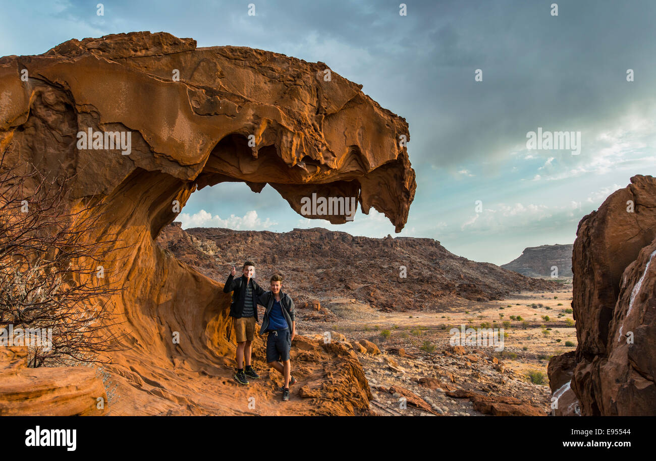 Zwei Jugendliche stehen auf einer Felsformation, Löwenmaul, Twyfelfontein, Namibia Stockfoto