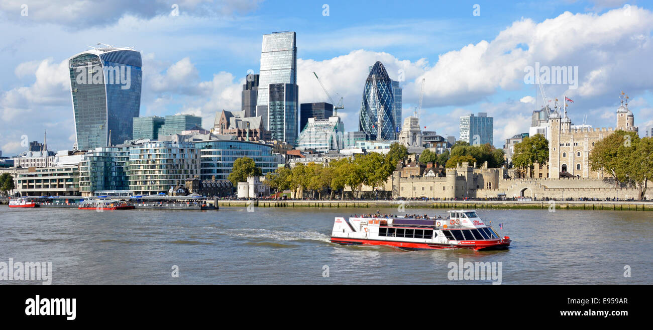 Thames Tour Boot & London Wolkenkratzer Skyline Wahrzeichen L to R Walkie Talkie Cheesegrater & Gherkin Zwerg Flussufer historischen alten Tower of London UK Stockfoto