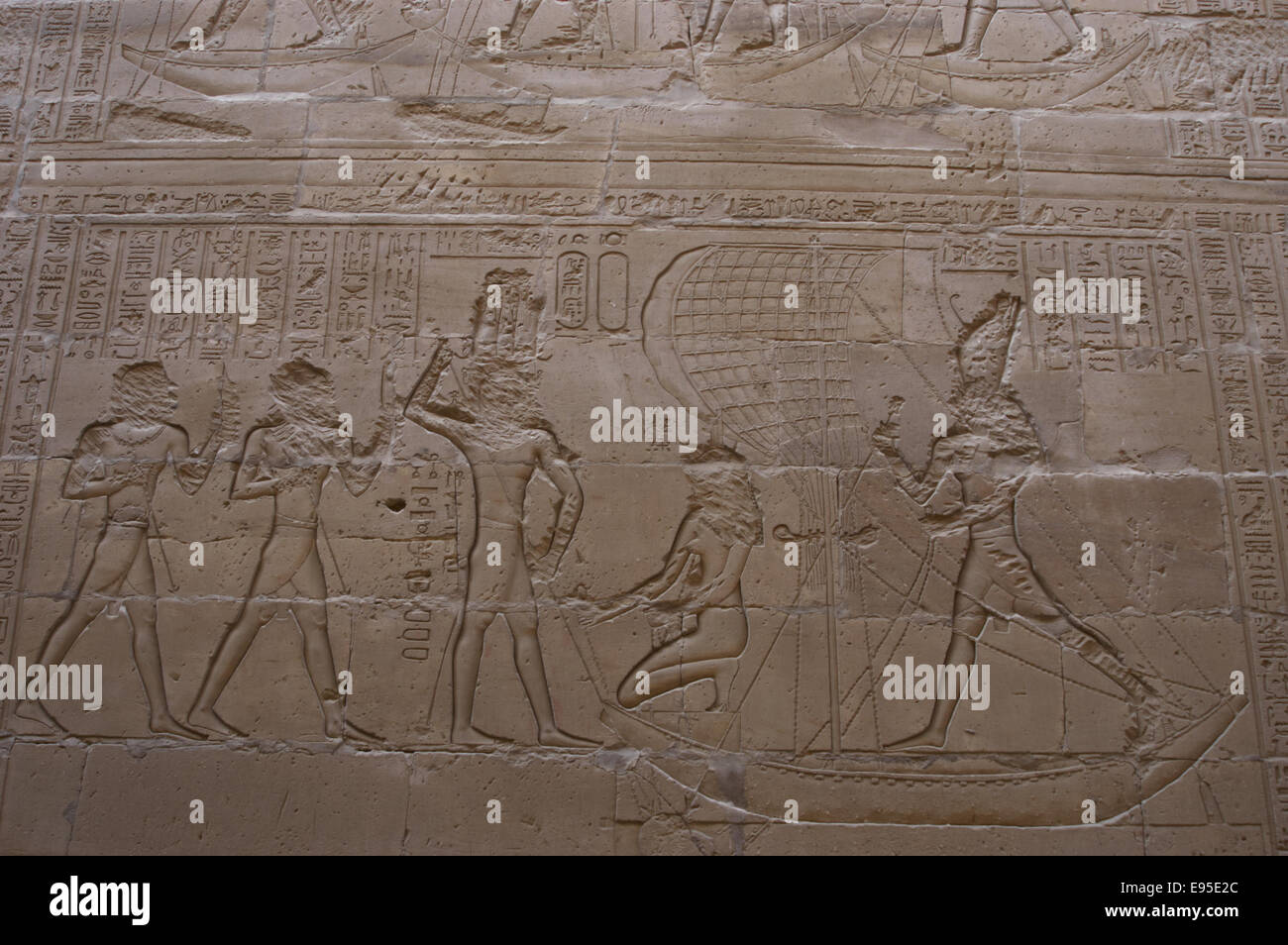 Ägypten. Edfu. Tempel des Horus. Horus, stehend, und Isis, kniend, auf einem Schiff mit einem Segel, das Nilpferd (Seth) erfassen. Relief. Stockfoto