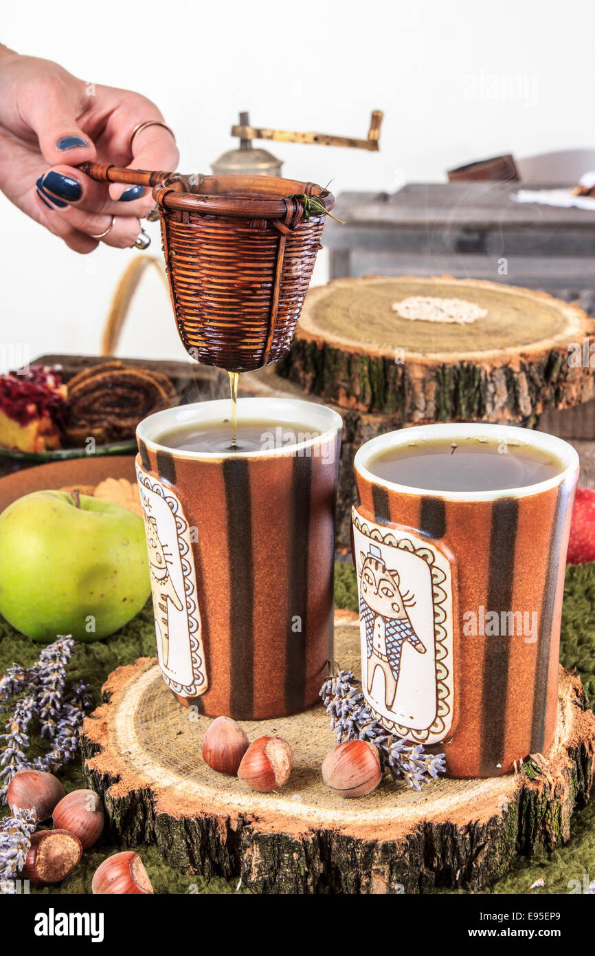 Alte Haus Tisch Teetassen und Sieb auf hölzernen stumpf in romantische Vintage Komposition Stockfoto