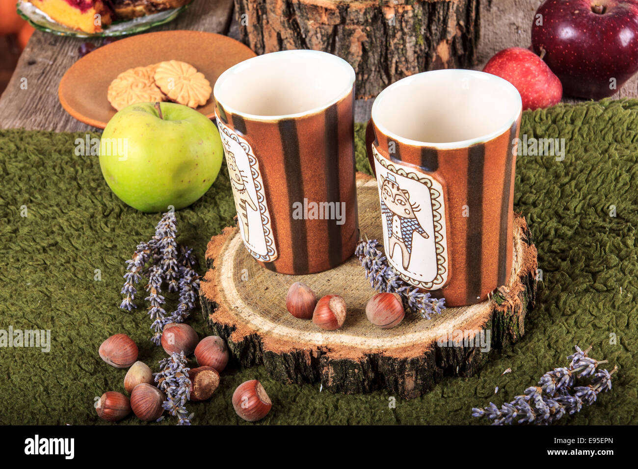 Retro-Komposition mit Teetassen und Kekse und Äpfel auf Tisch mit Haselnüssen rund um Stockfoto