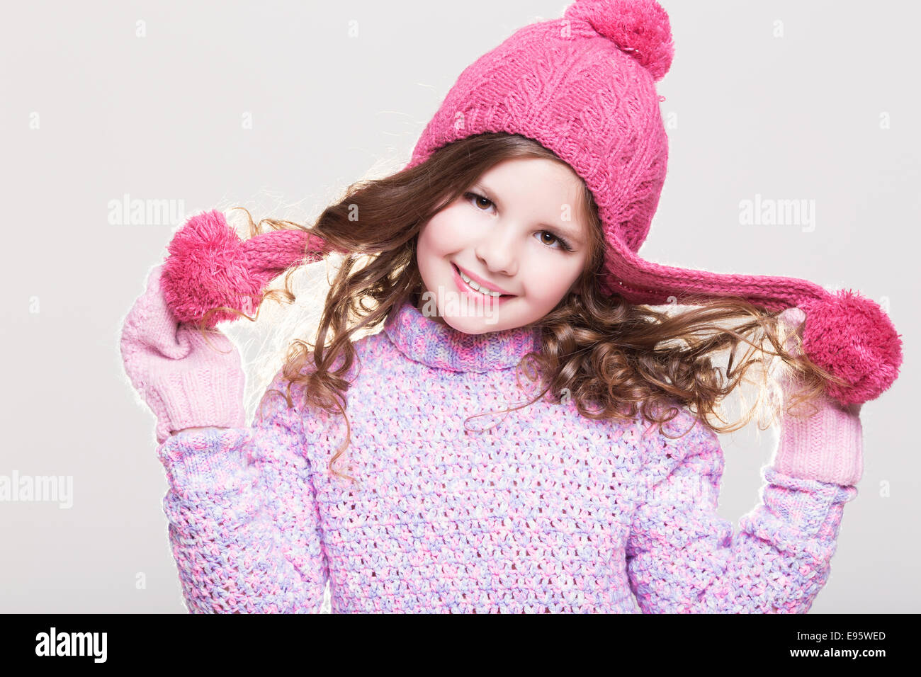 Glückliches kleines Kind in Winterkleidung, niedlichen Babymädchen in wollenen Zubehör, Studio, weißen Hintergrund. Kid im Winter Hut Handschuhe Stockfoto