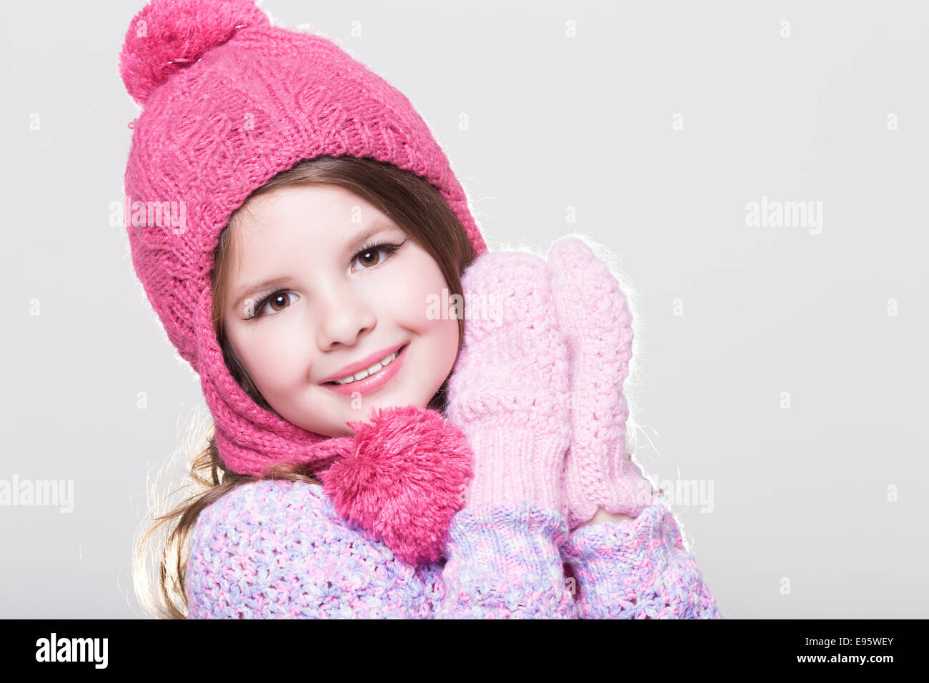 Glückliches kleines Kind in Winterkleidung, niedlichen Babymädchen in wollenen Zubehör, Studio, weißen Hintergrund. Kid im Winter Hut Handschuhe Stockfoto