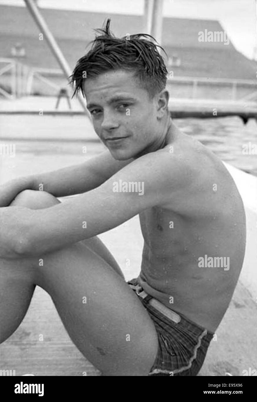 Ein Foto aus den 1940er bis 1950er Jahren eines jungen Mannes, der am Pool sitzt, Teil einer Sammlung von Fotos aus Fort Macleod, Alberta. Das Bild fängt einen entspannten Moment in einer Kleinstadt ein. Stockfoto