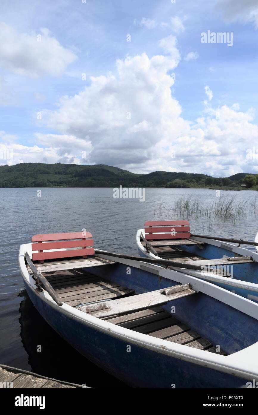 Zwei Ruderboote am Pier auf See als Hintergrund Stockfoto