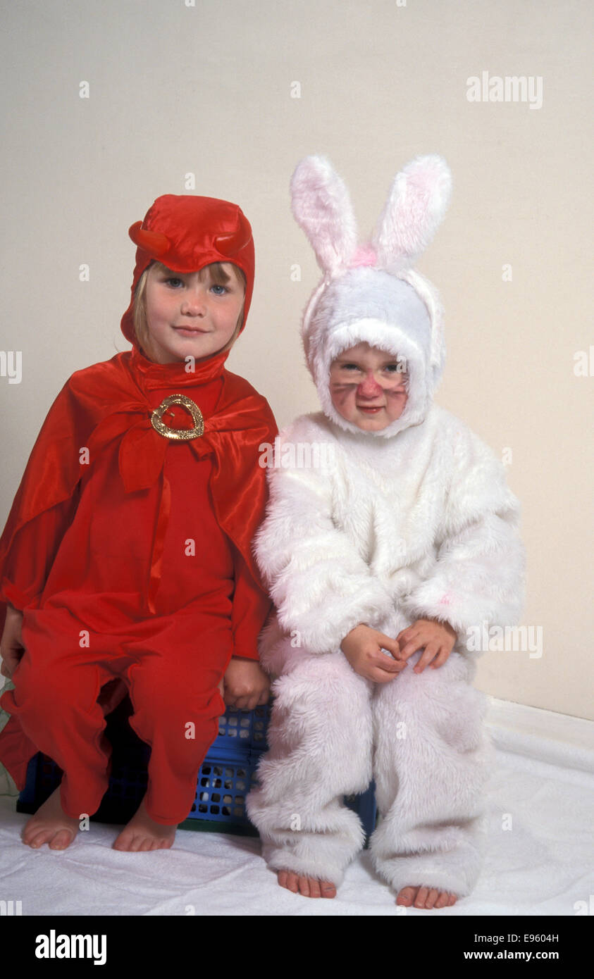 zwei kleine Mädchen verkleidete sich als kleine rote Teufel und Osterhase Stockfoto