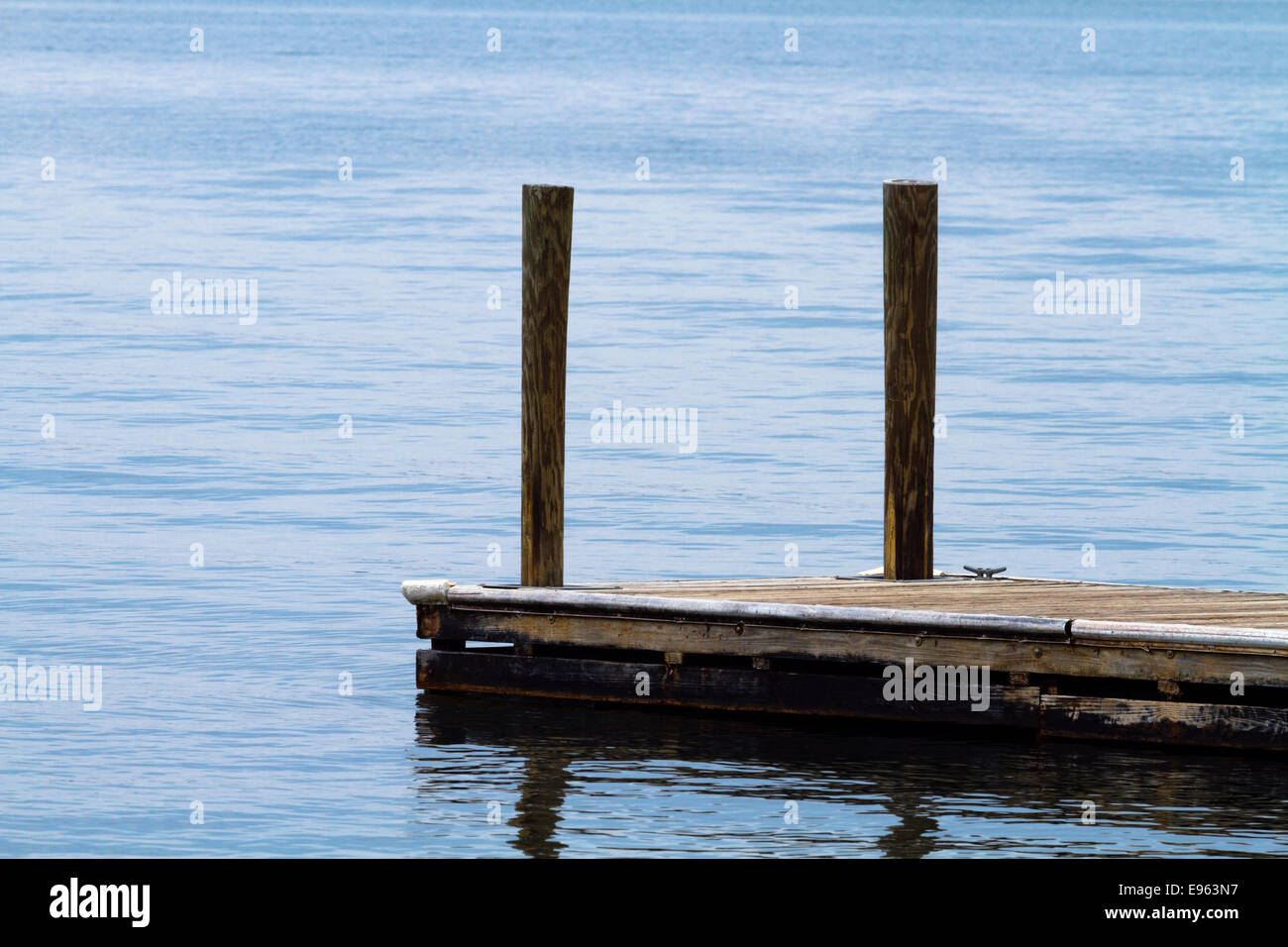 Eine einzelne alt, verwittert, schwimmende, Bootsanlegestelle aus Holzplanken und Beiträge bei Lake Murray, SC an einem bewölkten Tag. Stockfoto