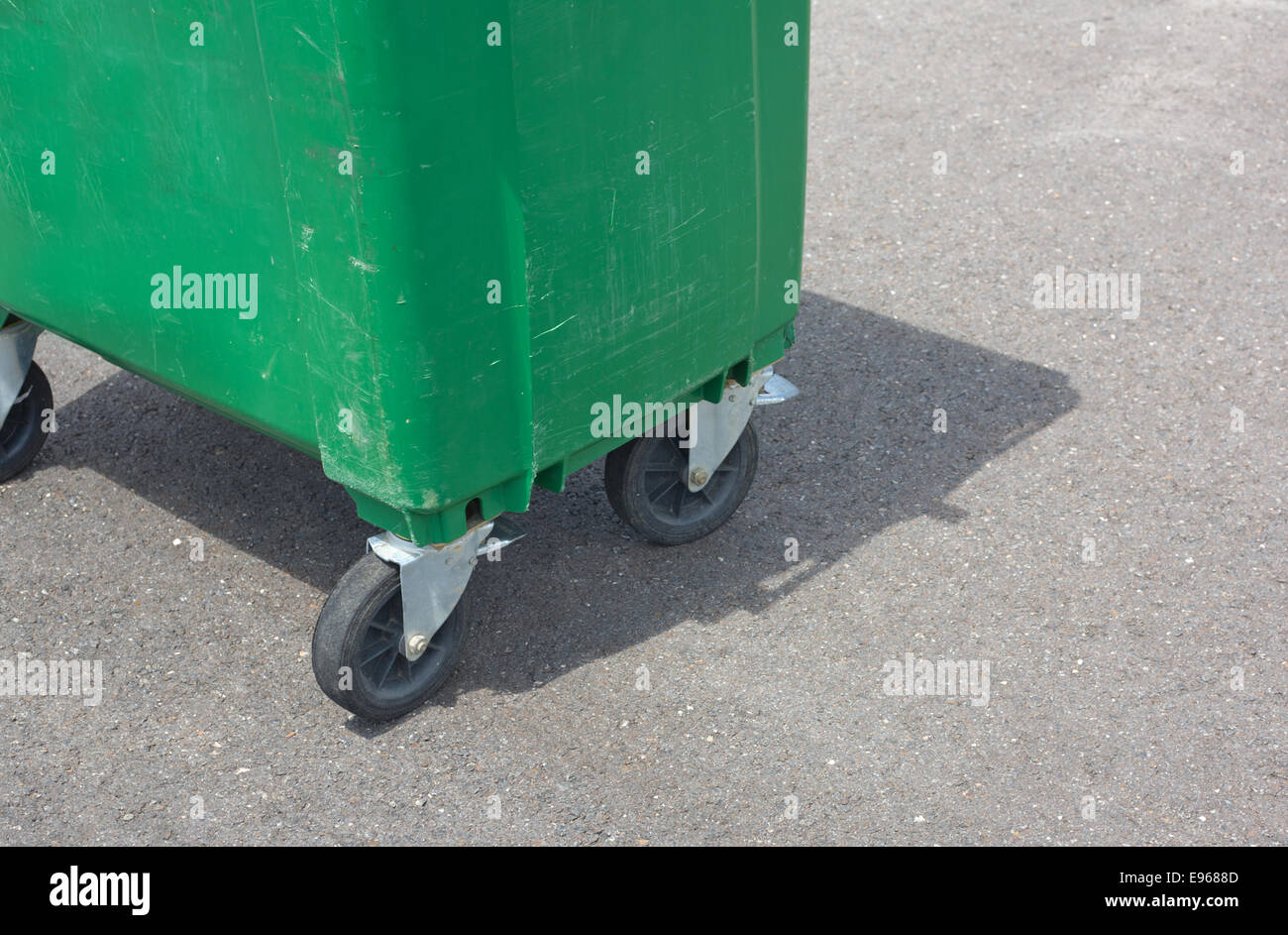 Eine grüne verwitterte Müllcontainer an der Straßenseite. Räder-detail Stockfoto