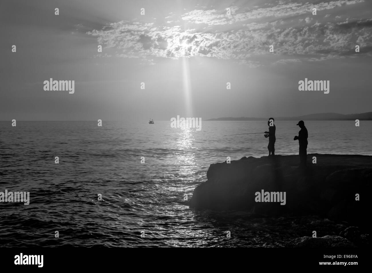 Am Abend Angeln am Mittelmeer. Turkei. Silhouette der Fischer. Schwarz und weiß. Stockfoto