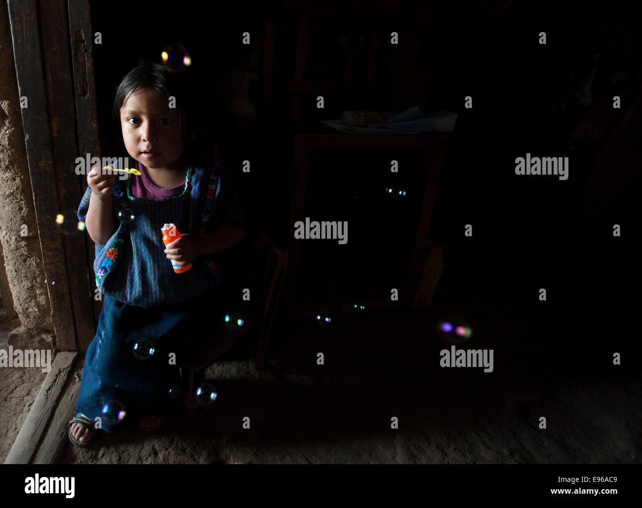 Eine indigene Maya-Mädchen spielt mit blowing Bubbles in San Antonio Palopo, Solola, Guatemala. Stockfoto