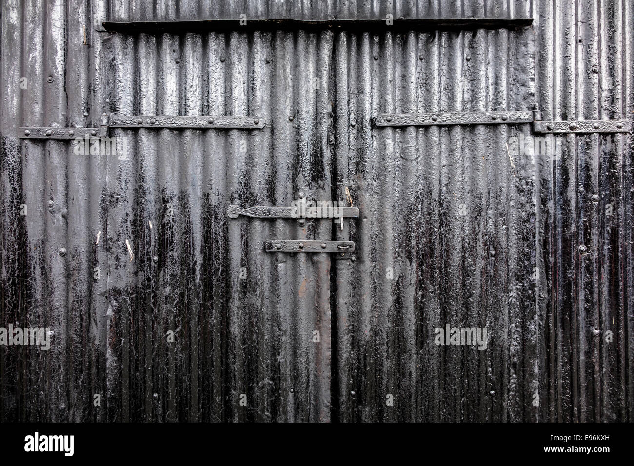 Eine gewellte Teer schwarzen Industrietor Hintergrund. Stockfoto