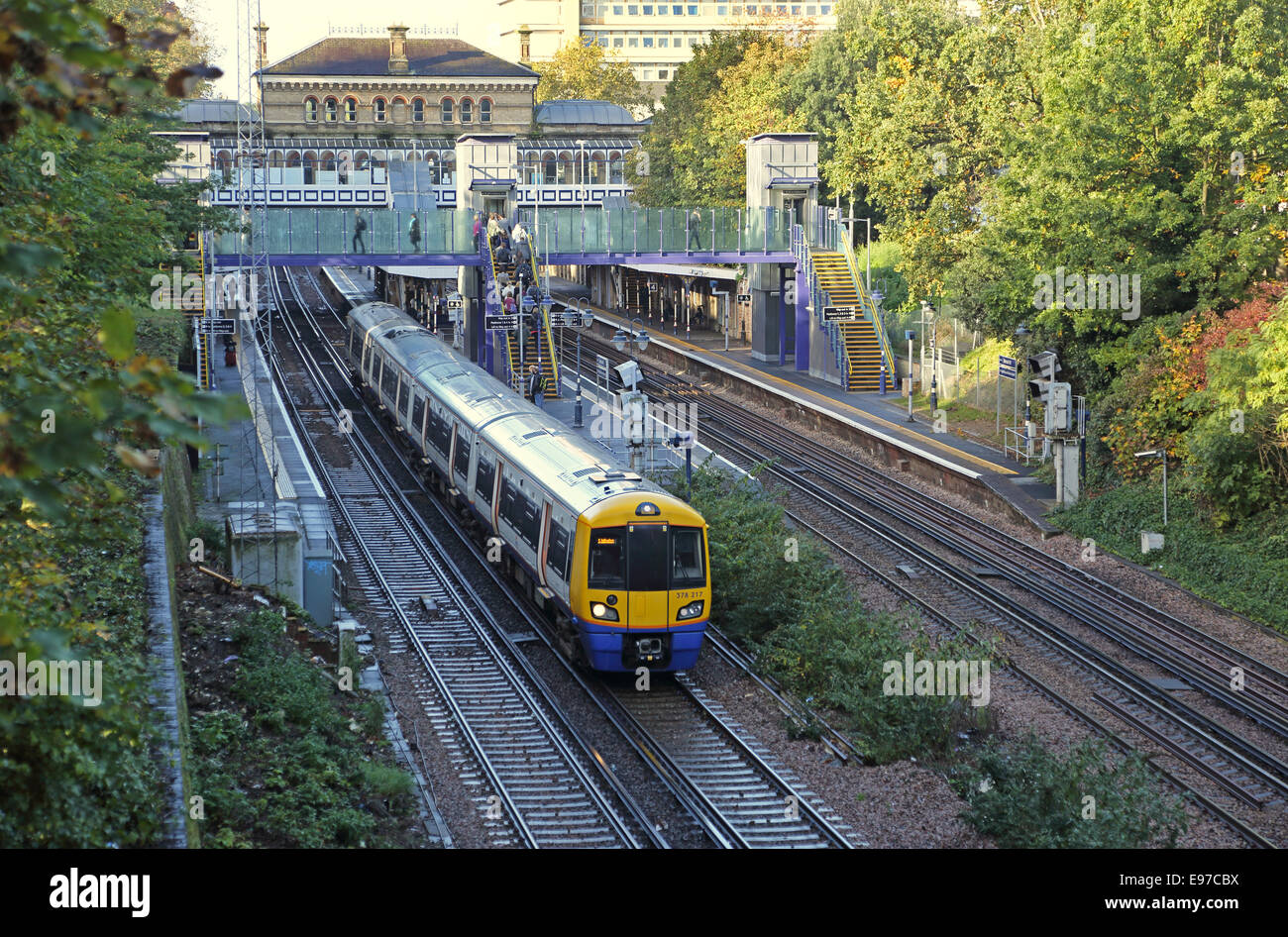 Denmark Hill Bahnhof, Südlondon. Ein Overground-Zug zieht weg. Zeigt stufenfreie neu Zugang über Aufzüge und Fußgängerbrücke Stockfoto