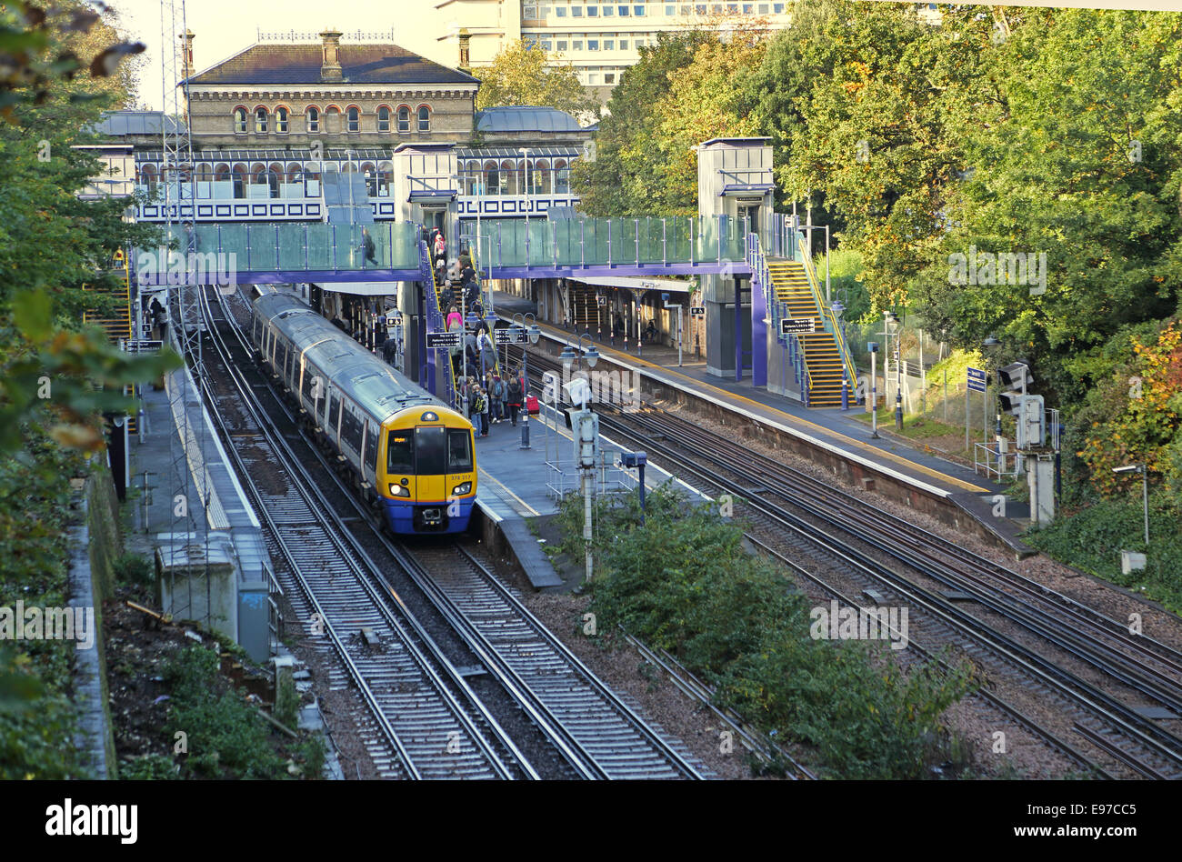 Denmark Hill Bahnhof in Süd-Ost-London. Ein Overground-Zug wartet am Bahnsteig. Zeigt neue Lifte und Steg. Stockfoto