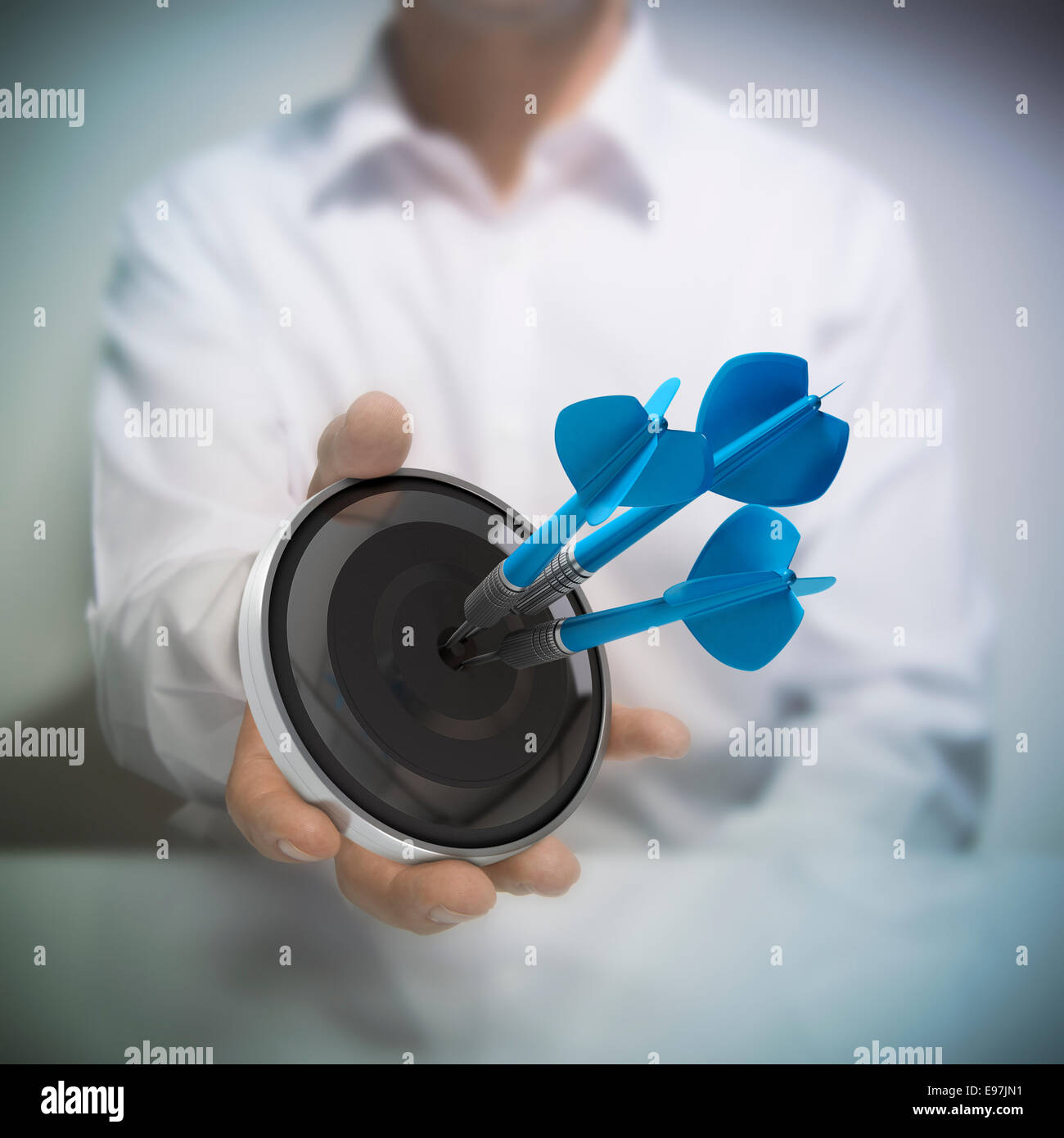Mann hält auf schwarzen Ziel mit drei blauen Pfeilen trifft das Zentrum. Konzept-Bild zur Veranschaulichung der Marketing- und advertisin Stockfoto