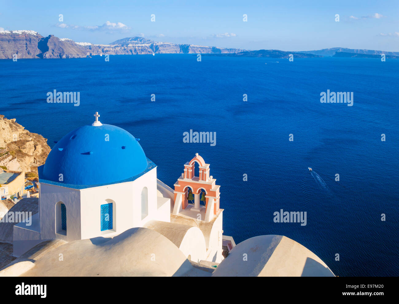 Weiße griechische Kirche mit blauer Kuppel & rosa Glockenturm, Oia, Santorini, Thira, Kykladen, griechische Inseln, Griechenland, EU, Europa Stockfoto