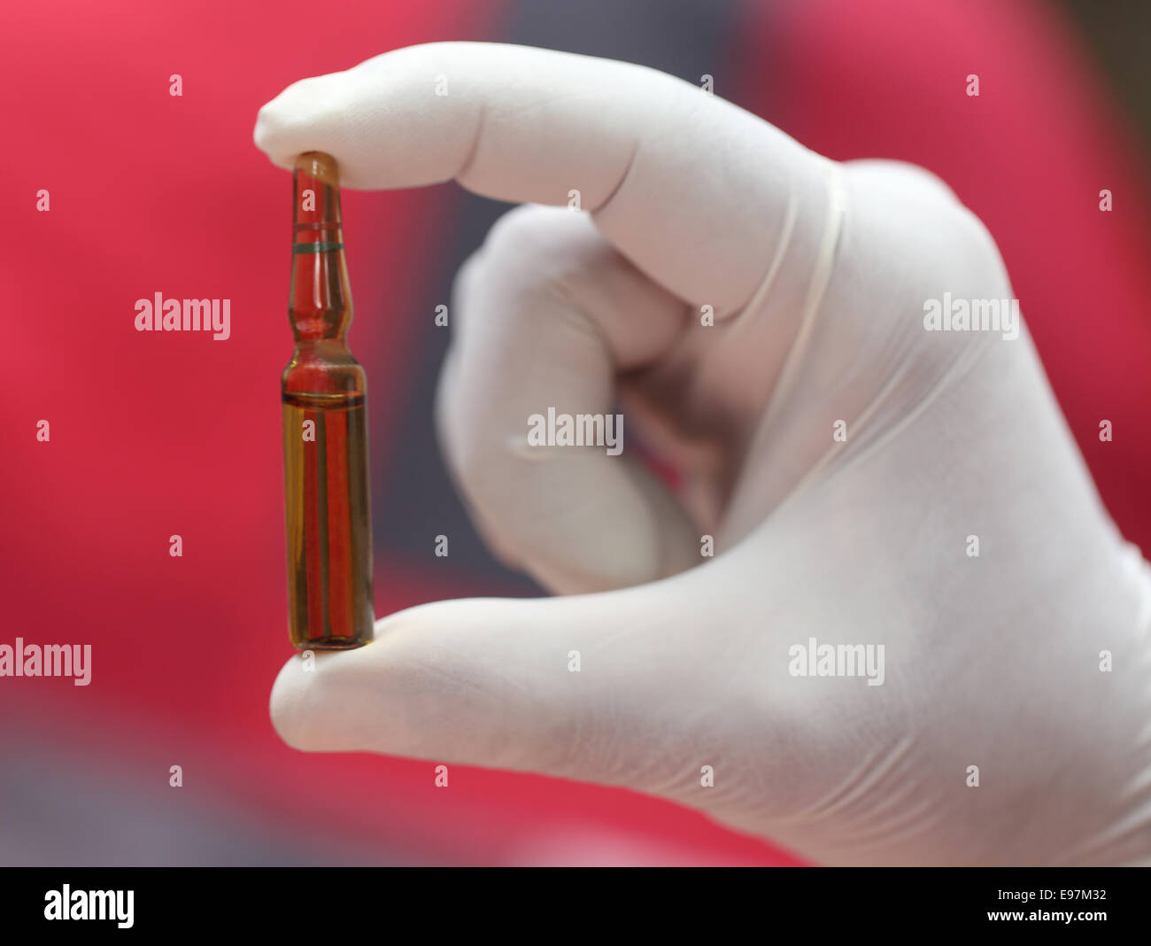 Nahaufnahme von einer Ampulle hält per hand mit Handschuhen Stockfoto