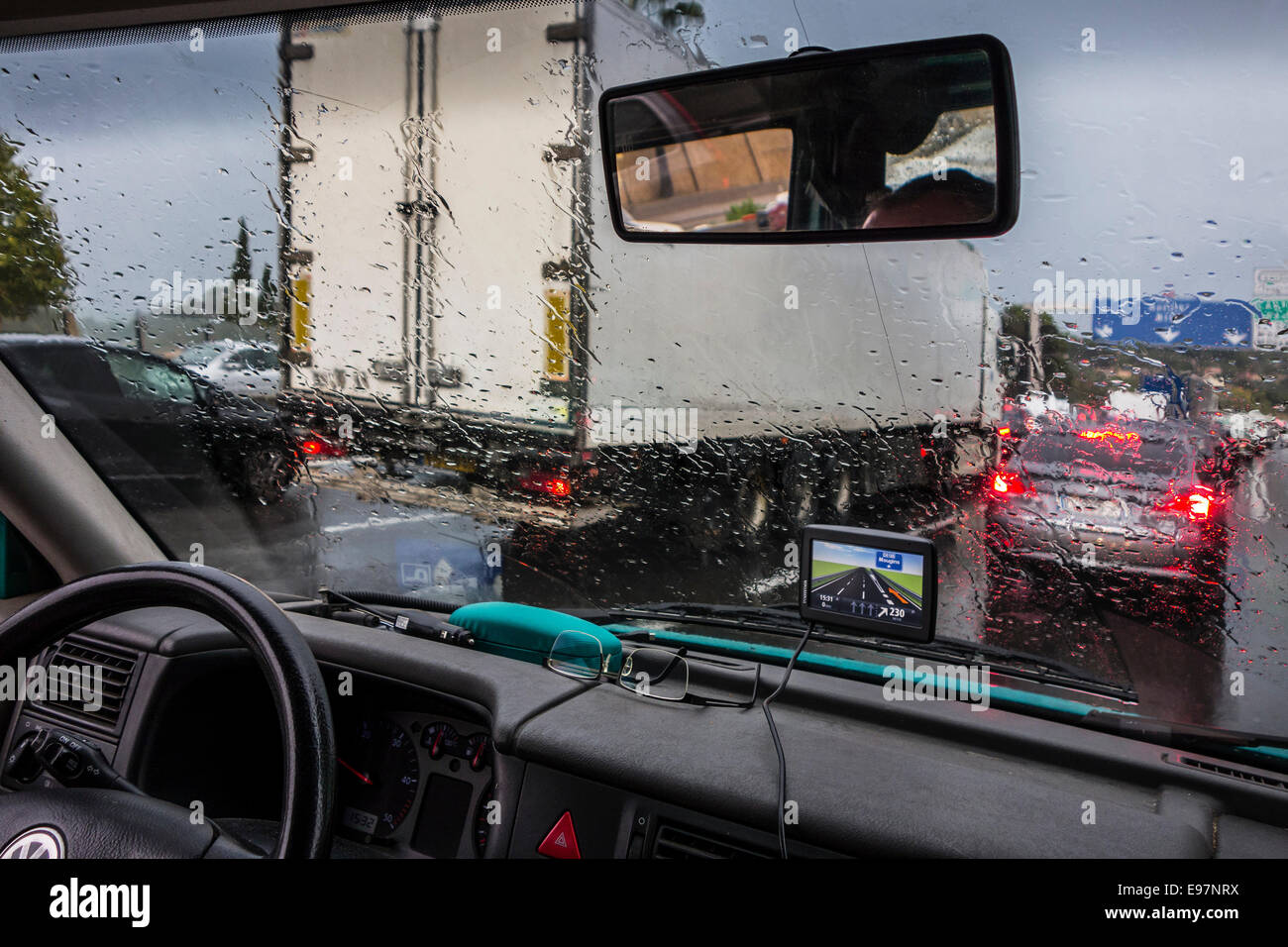 LKW, Autos auf der Autobahn überholen während starkem Regendusche innerhalb des Fahrzeugs mit großen Regentropfen auf der Windschutzscheibe aus gesehen Stockfoto