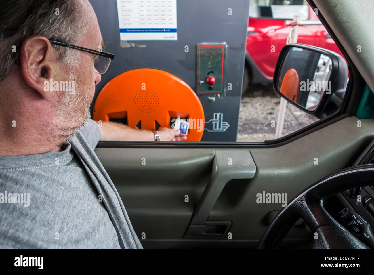 Fahrer im Auto nehmen Ticket von unbemannten automatischen Ticket Abgabe Maschine an Mautstelle zur Anbindung an die Autobahn / Autobahn Stockfoto