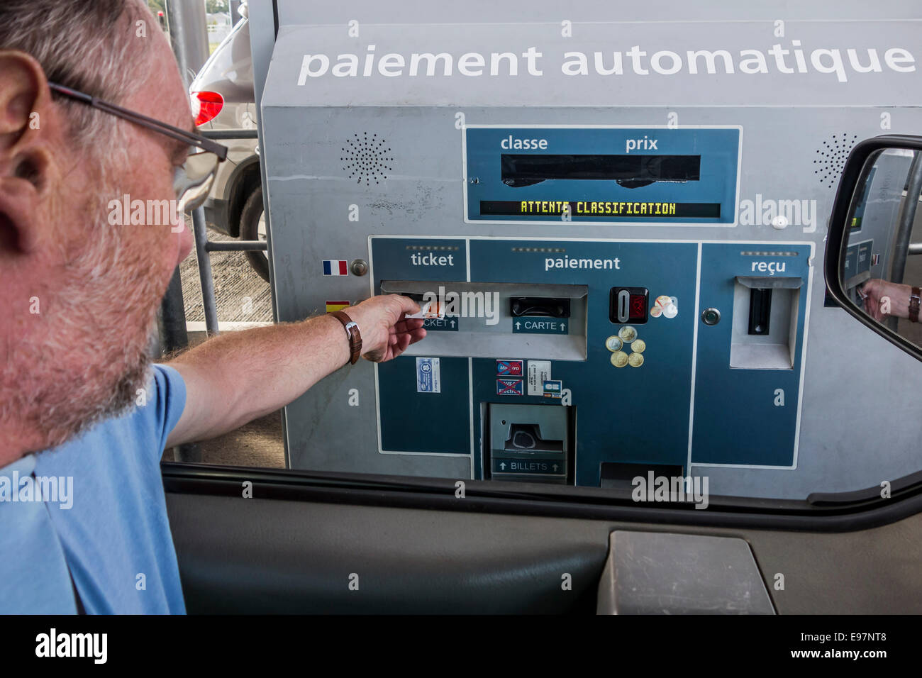 Fahrer im Auto Automatik / elektronische Maut Sammlung Maschine vor der Zahlung mit Kreditkarte bei Mautstelle Ticket ins Stockfoto