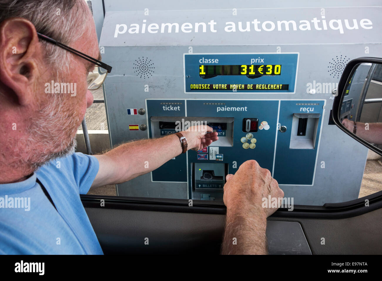 Fahrer im Auto bezahlen mit Kreditkarte an Automatik / elektronische Mautstelle Sammlung auf der französischen Autobahn Stockfoto