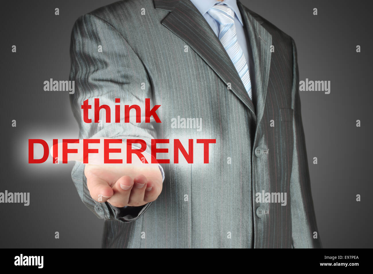 Mann hält virtuelle Worte "Think different" auf dunklem Hintergrund Stockfoto