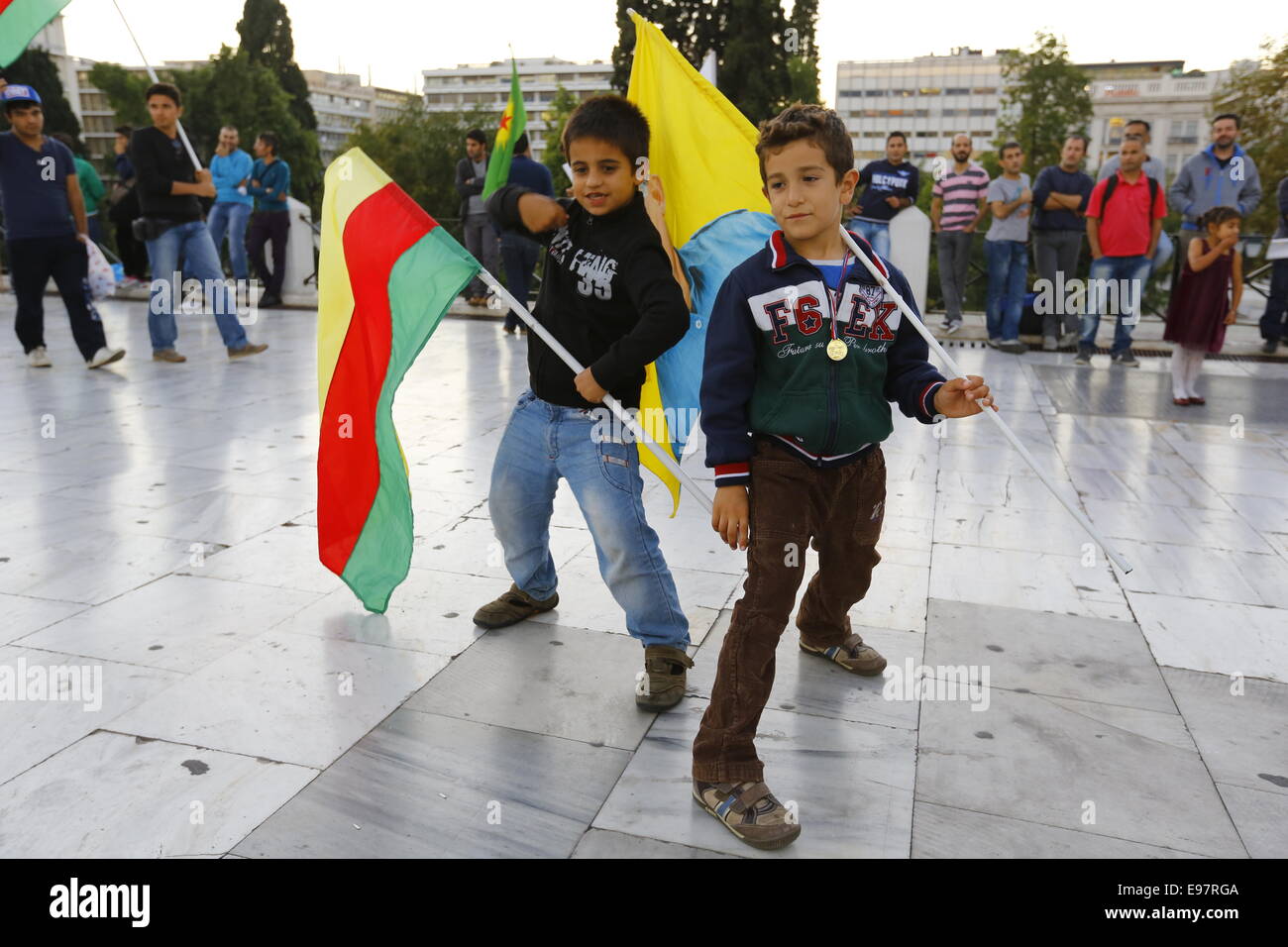 Athen, Griechenland. 21. Oktober 2014. Zwei jungen kurdischen posieren für die Kameras hält eine Fahne, die durch die syrischen Kurden Basis verwendet wird und eine Fahne mit dem Bild des inhaftierten PKK (kurdische Arbeiterpartei) Führer Abdullah Öcalan. Kurden leben in Griechenland marschierte in die Europäische Union (EU) Büros in Athen gegen die Angriffe von islamischer Staat (IS) Kämpfer auf die Stadt Kobane in Syrien zu protestieren. Ihre Wut richtete sich vor allem in Richtung Türkei und die Untätigkeit der türkischen Armee, auf die Hilfe von der belagerten Stadt zu kommen. Bildnachweis: Michael Debets/Alamy Live-Nachrichten Stockfoto