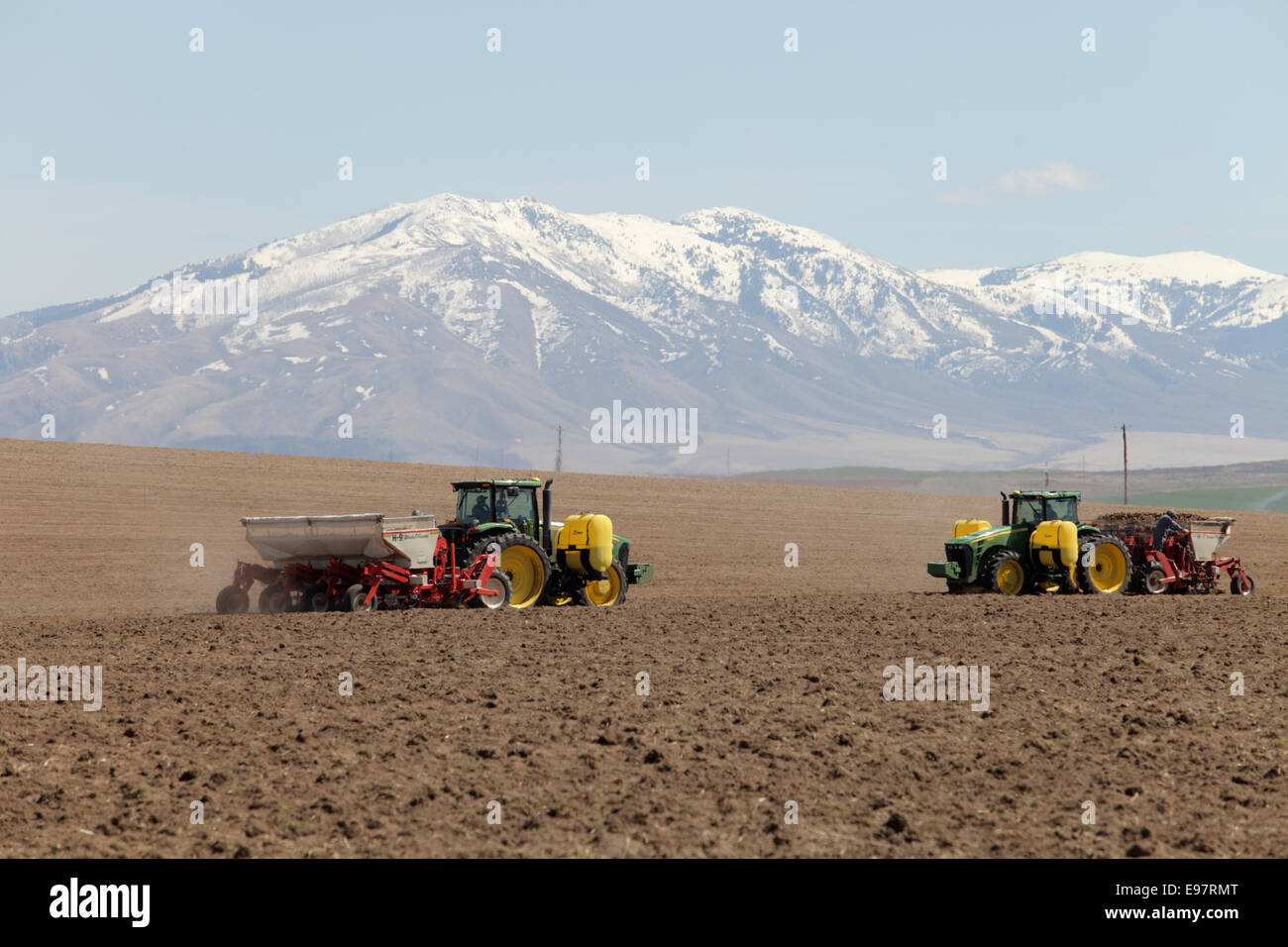 Traktoren arbeiten pflanzende Kartoffeln in den fruchtbaren Feldern von Idaho. Stockfoto