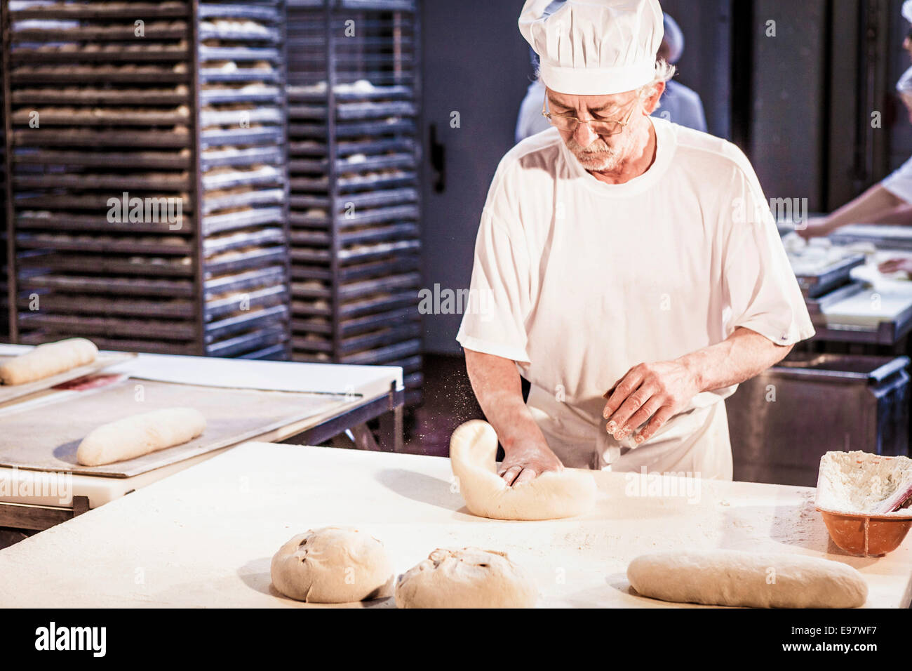 Herstellung von Brot, senior Bäcker Teig kneten Stockfoto
