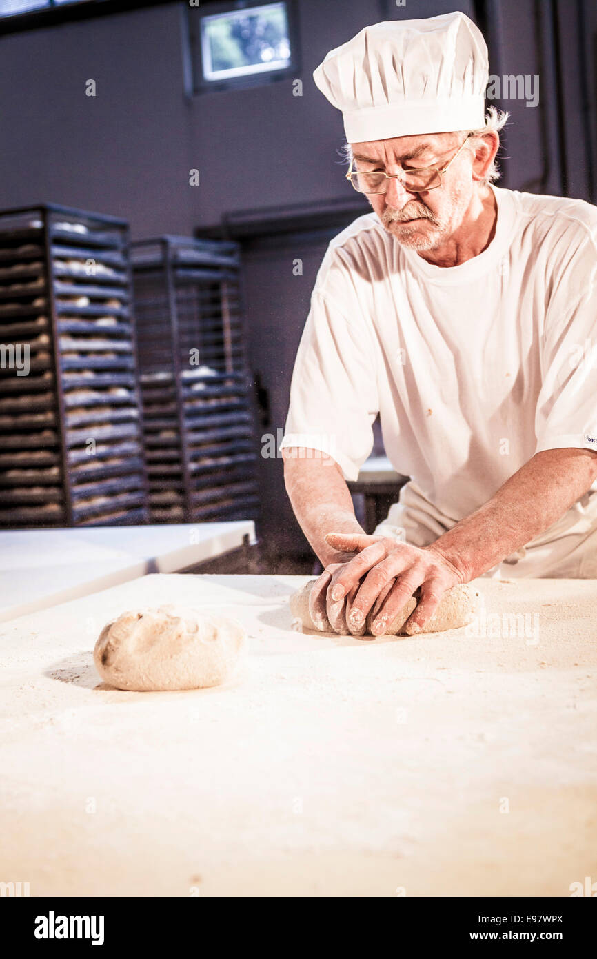 Herstellung von Brot, senior Bäcker Teig kneten Stockfoto