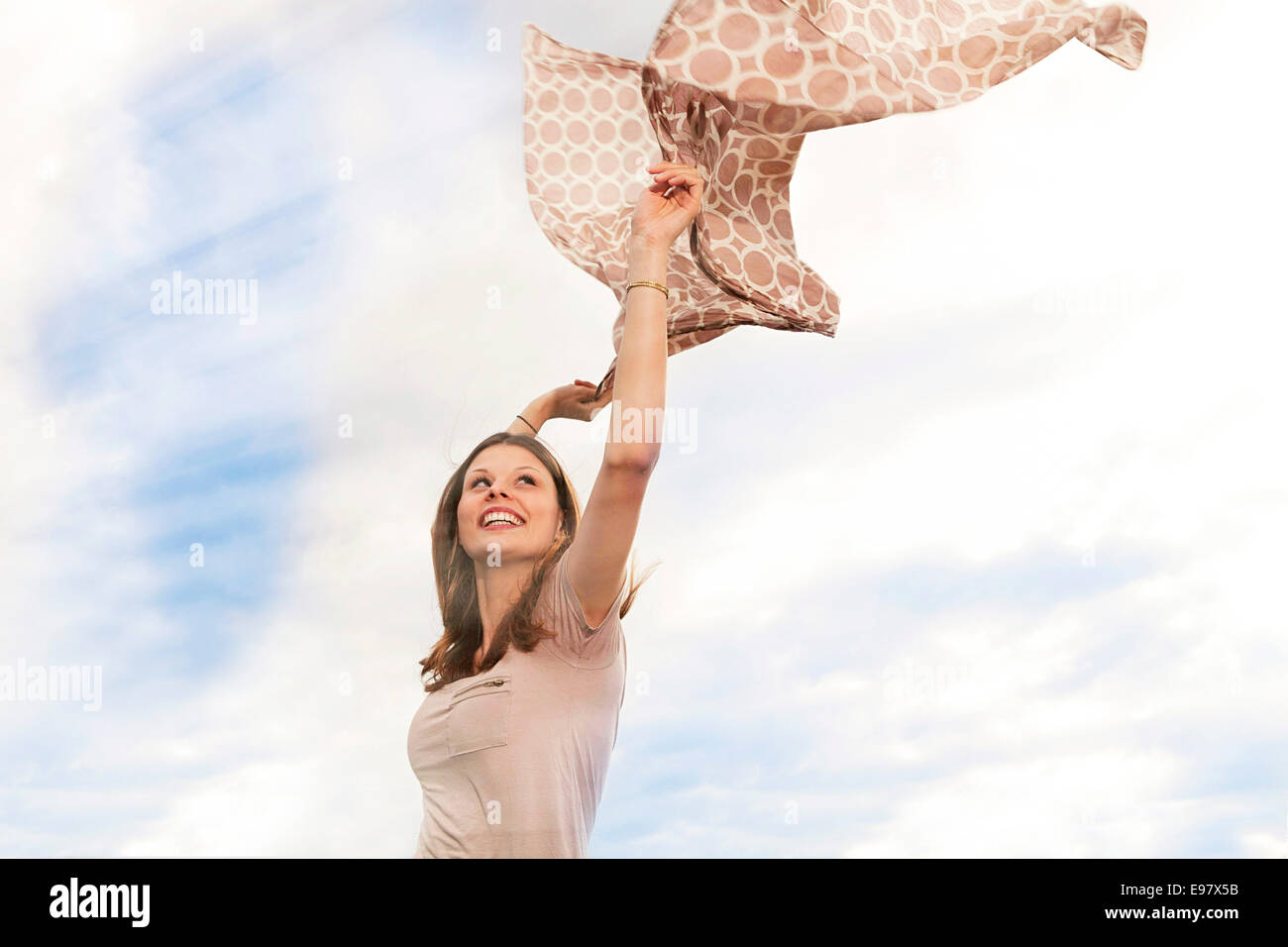 Junge Frau spielt mit Schal im Wind, München, Bayern, Deutschland Stockfoto