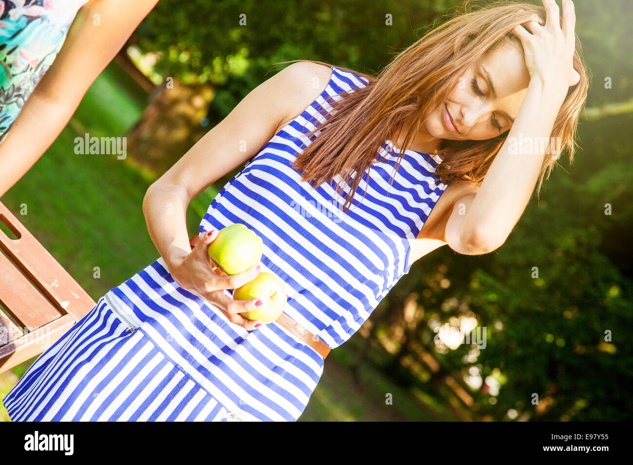 Junge Frau in gestreiften Hemd halten Äpfel in der hand Stockfoto