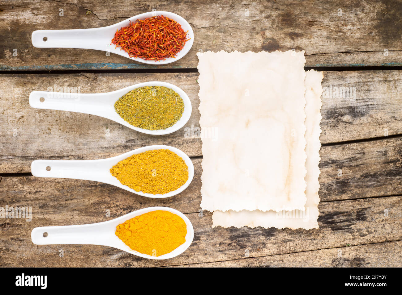 Gewürze-Rezept-Hintergrund. Vielfalt der würzigen Pulver mit Papierblatt. Ansicht von oben Stockfoto