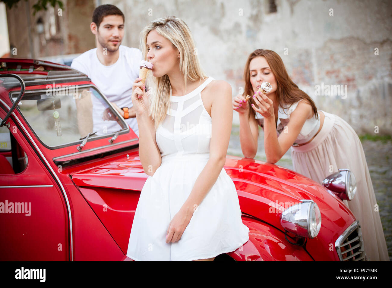 Junge Leute essen Eis mit dem Auto Stockfoto
