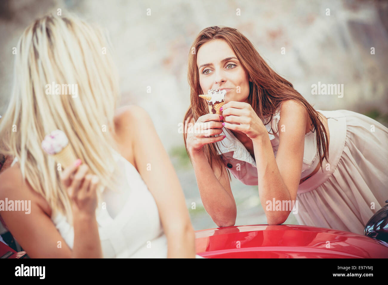 Zwei junge Frauen, Eis essen, mit dem Auto Stockfoto