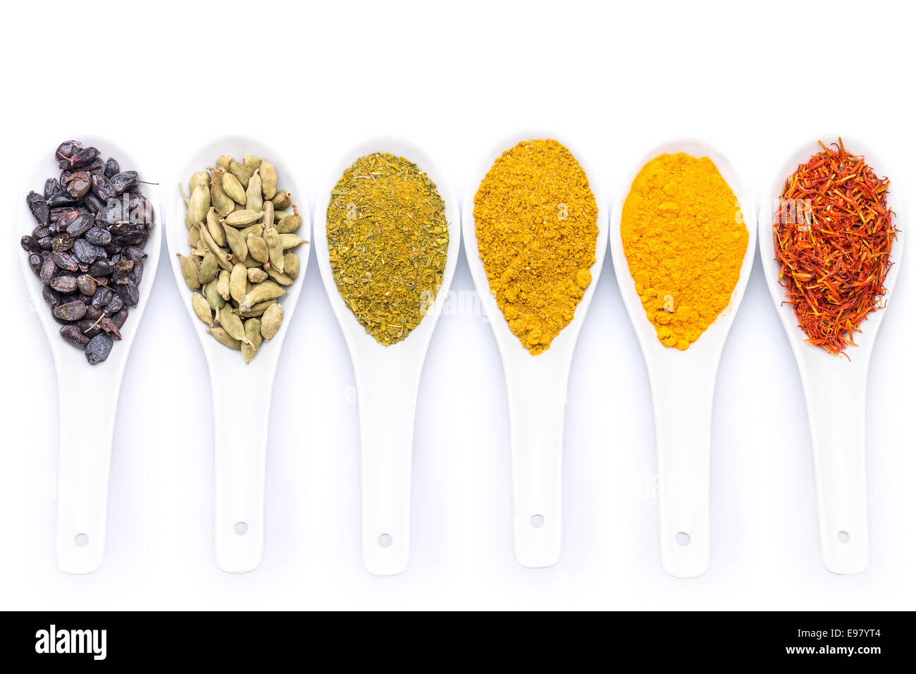 Diverse Gewürze in Keramik Löffel isoliert auf weißem Hintergrund Stockfoto