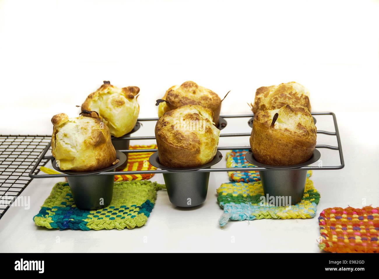 6 Popover in in Popover pan sitzen auf Top 5 mehrfarbige bunte quadratische Topflappen. Alle Objekte sind isoliert gegen weiß Stockfoto