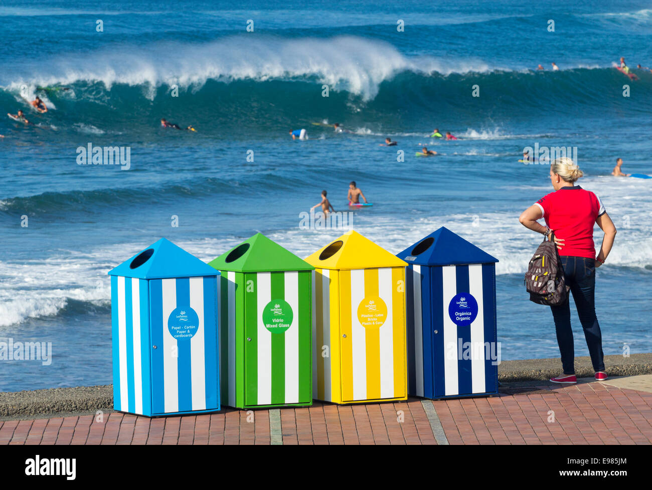 Recycling-Behälter am Las Canteras Strand bei Surfern im Hintergrund. Las Palmas, Gran Canaria, Kanarische Inseln, Spanien Stockfoto