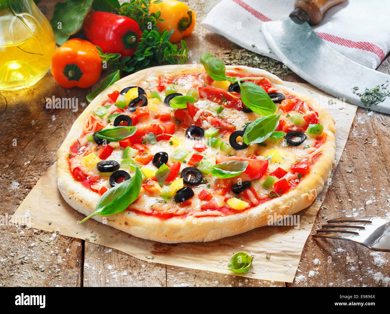 Leckere hausgemachte Pizza mit einem dicken goldenen Sockel belegt mit Käse, Tomaten, Paprika, Oliven und Kräutern Stockfoto