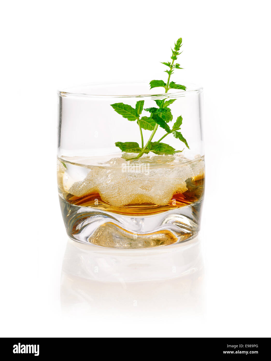 Alkoholisches Getränk mit Minze und Eiswürfeln. Schnaps in ein Glas mit Eis und einige Kräuter, die isoliert auf weißem Hintergrund Stockfoto